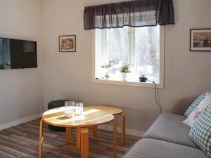 een woonkamer met een tafel, een bank en een raam bij Holiday home HUNNEBOSTRAND XII in Hunnebostrand