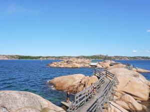 a bridge over a body of water with people on the rocks at Holiday home HUNNEBOSTRAND XII in Hunnebostrand