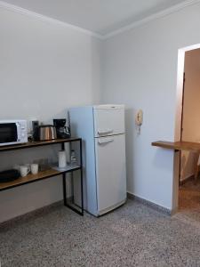 einen weißen Kühlschrank in einem Zimmer mit einer Theke in der Unterkunft Castellanos Departamento Temporario in Santa Fe