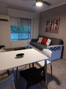 ein Wohnzimmer mit einem Tisch und einem Sofa in der Unterkunft Castellanos Departamento Temporario in Santa Fe
