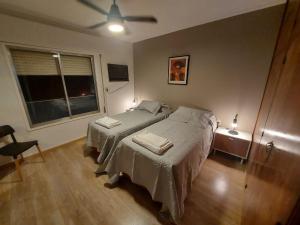 Schlafzimmer mit einem Bett und einem Deckenventilator in der Unterkunft Castellanos Departamento Temporario in Santa Fe
