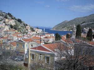 a group of houses on a hill next to the water at GRANDMA'S HOUSE in Symi