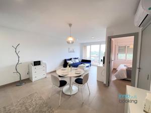 sala de estar con mesa y dormitorio en Sun Beach CYE Salou, climatizado, piscina y Pk en Salou