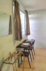 a table and chairs in a room with a window at Studio 2 em Itapuã 900m da praia! in Salvador