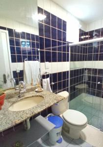 a bathroom with a toilet and a sink and a shower at Studio 2 em Itapuã 900m da praia! in Salvador