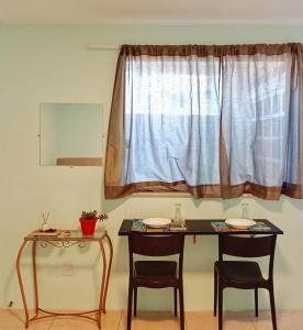 a table and two chairs in front of a window at Studio 2 em Itapuã 900m da praia! in Salvador