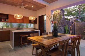a kitchen and dining room with a wooden table and chairs at Abivilla in Seminyak