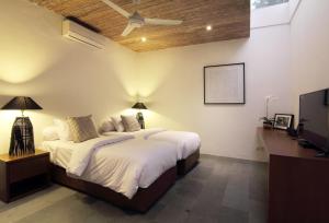 a bedroom with a bed and a ceiling fan at Abivilla in Seminyak