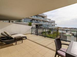 balkon z krzesłami oraz budynek w budynku w obiekcie Apartment in Mijas Costa with garage w mieście Mijas Costa