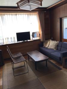 a living room with a couch and a table at Blue 200-1 / Vacation STAY 3808 in Utasutsu