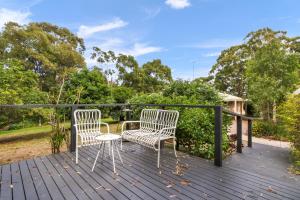 two chairs and a table on a deck at Aruma - Peaceful Metung Getaway in Metung