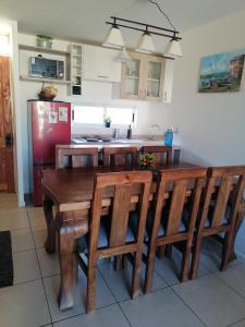 Dpto Bordemar 1 في لاس كروسيس: مطبخ مع طاولة وكراسي خشبية وثلاجة