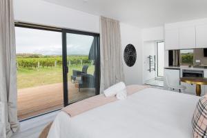 um quarto com uma cama e uma grande janela com vista em Matawhero Wines em Gisborne