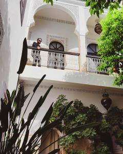 a woman standing on a balcony of a building at Riad Amegrad in Marrakesh