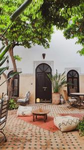 un patio con puerta, mesa y bancos en Riad Amegrad en Marrakech