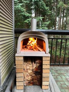 a wood fired oven with a fire in it at Forest House Yamanakako in Yamanakako