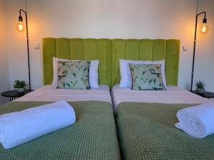 two beds in a room with a green headboard at Lost Inn Porto Hostel in Porto
