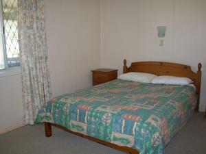 a bedroom with a bed with a quilt and a window at White Dolphin Unit 5 in Gold Coast