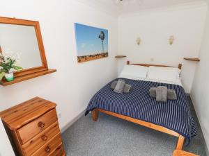 ハバーフォードウェストにあるCorner Cottageのベッドルーム1室(ベッド1台、木製ドレッサー付)