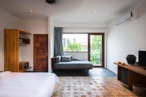 ein Schlafzimmer mit einem Bett, einem Stuhl und einem Fenster in der Unterkunft Pages Rooms Hotel in Siem Reap