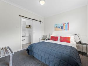 
a bedroom with a bed and a dresser at Golfers Lodge Unit 1 in Narooma

