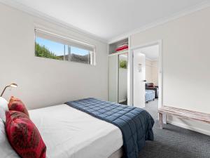
a bedroom with a bed and a window at Golfers Lodge Unit 1 in Narooma
