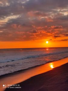 una puesta de sol en una playa con el océano en Cabina de vacances caballo del mar sur la plage en Parrita