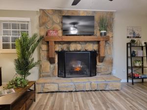 a living room with a stone fireplace with a flat screen tv at Just Breathe in Dandridge