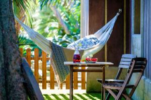 een hangmat op een patio met een tafel en een stoel bij O Refúgio - Espaço natural, amplo e privado in Angra do Heroísmo