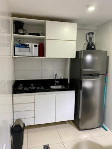 Elle comprend une petite cuisine équipée d'un réfrigérateur en acier inoxydable. dans l'établissement Apartamento em João Pessoa a Poucos Metros do Mar, à João Pessoa