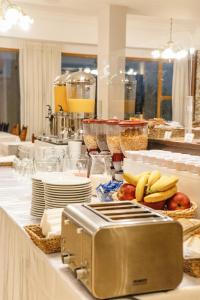 a buffet line with bananas and plates and a toaster at Hotel Concorde in San Carlos de Bariloche