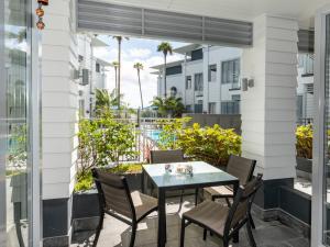 a patio with a table and chairs on a balcony at Oceanside - Paihia Waterfront Apartment in Paihia