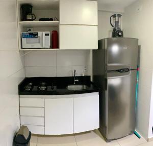 una pequeña cocina con nevera de acero inoxidable en Apartamento em João Pessoa a Poucos Metros do Mar, en João Pessoa