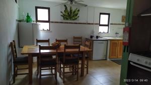 a kitchen with a wooden table and chairs in it at Casa DE Amigos in Ancião