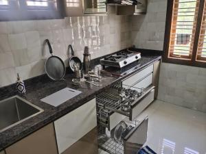 a kitchen with a stove and a counter top at Corner apartment, 2BHK with good privacy, parking in Bangalore
