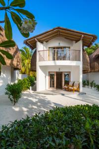 a house on the beach with a balcony at Bandos Maldives in North Male Atoll