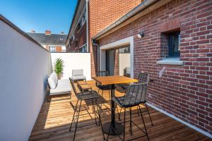 a balcony with a wooden table and chairs at DOWNTOWN ROOFTOP - CENTRE VILLE - WiFi - TERRASSE - NETFLIX in Amiens