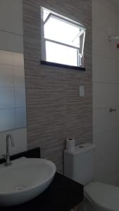 a bathroom with a sink and a toilet and a window at atalaia mar I in Aracaju