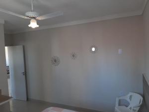 a room with a ceiling fan and a white wall at atalaia mar I in Aracaju