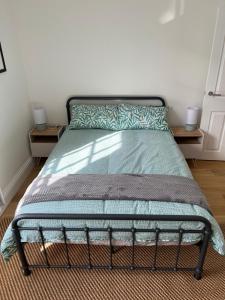 - un lit avec un couvre-lit vert et 2 tables de nuit dans l'établissement Lovely 1 Bed flat *FREE PARKING* Hoe/Barbican Plymouth, à Plymouth