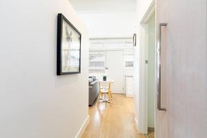 un corridoio con specchio e tavolo in una stanza di Modern Stylish Self-contained Studio Apartment a Burnside