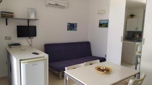 uma sala de estar com um sofá azul e uma mesa em lu Ientu house in Otranto, Baia dei Turchi area em Alimini
