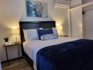 a bedroom with a large bed with blue sheets and pillows at The White Bungalow in Rosarito