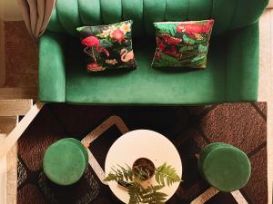 a green couch with two pillows and a table at Dốc Garden Homestay Đà Lạt in Da Lat
