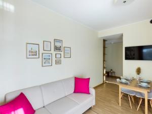 salon z białą kanapą i różowymi poduszkami w obiekcie SKY GARDEN w Jurmale