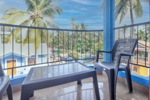 een tafel en een stoel op een balkon met uitzicht bij Blue rays in Calangute