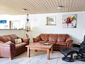 a living room with two brown leather couches and a table at 6 person holiday home in Asn s in Asnæs