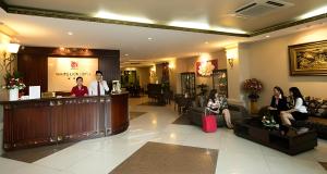 a lobby of a hotel with people sitting at a bar at White Lion Hotel in Ho Chi Minh City