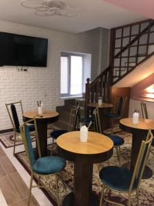 a restaurant with tables and chairs and a tv at Samal-2 Hotel in Almaty