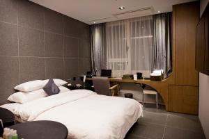 a bedroom with a bed and a desk with a computer at Hotel The Designers Hongdae in Seoul